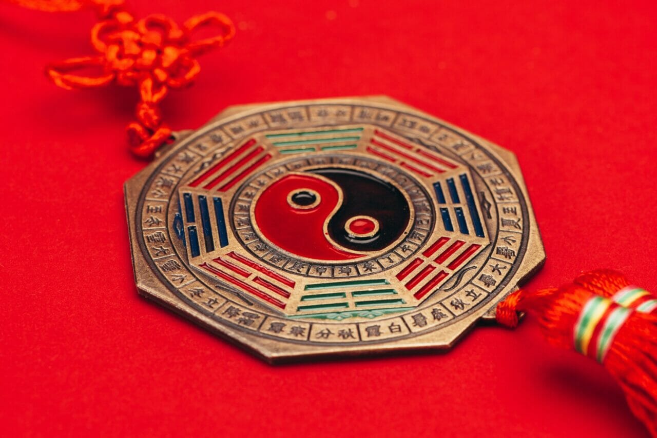 close up shot of traditional chinese yin and yang talisman on red surface