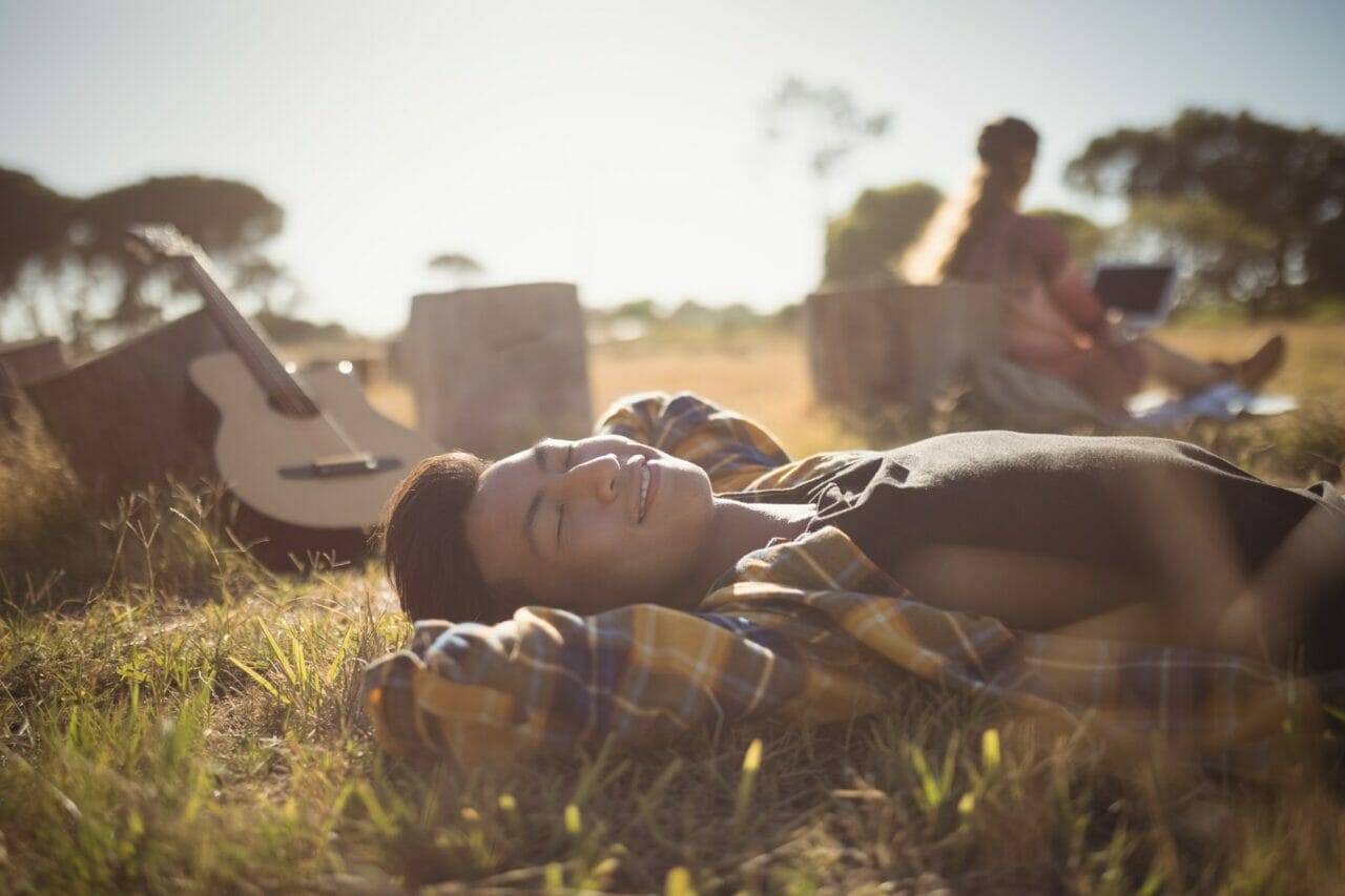 ypung man resting on grassy field